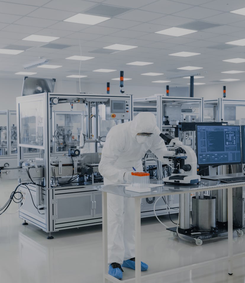Shot of Sterile Pharmaceutical Manufacturing Laboratory where Scientists in Protective Coverall's Do...