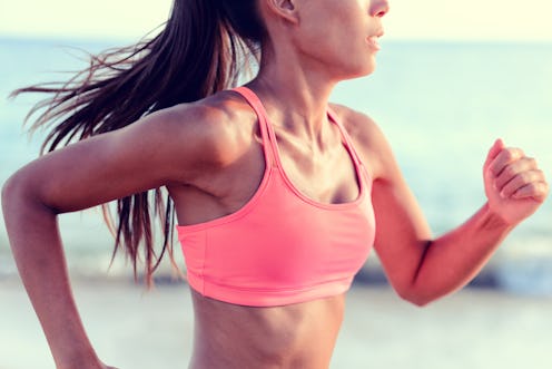 Cardio running workout - Upper body closeup crop of unrecognizable woman runner in fast motion showi...