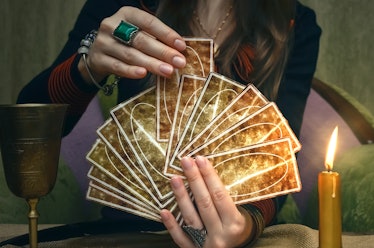 Tarot cards on fortune teller desk table. Future reading. Woman fortune teller holding and hands a d...