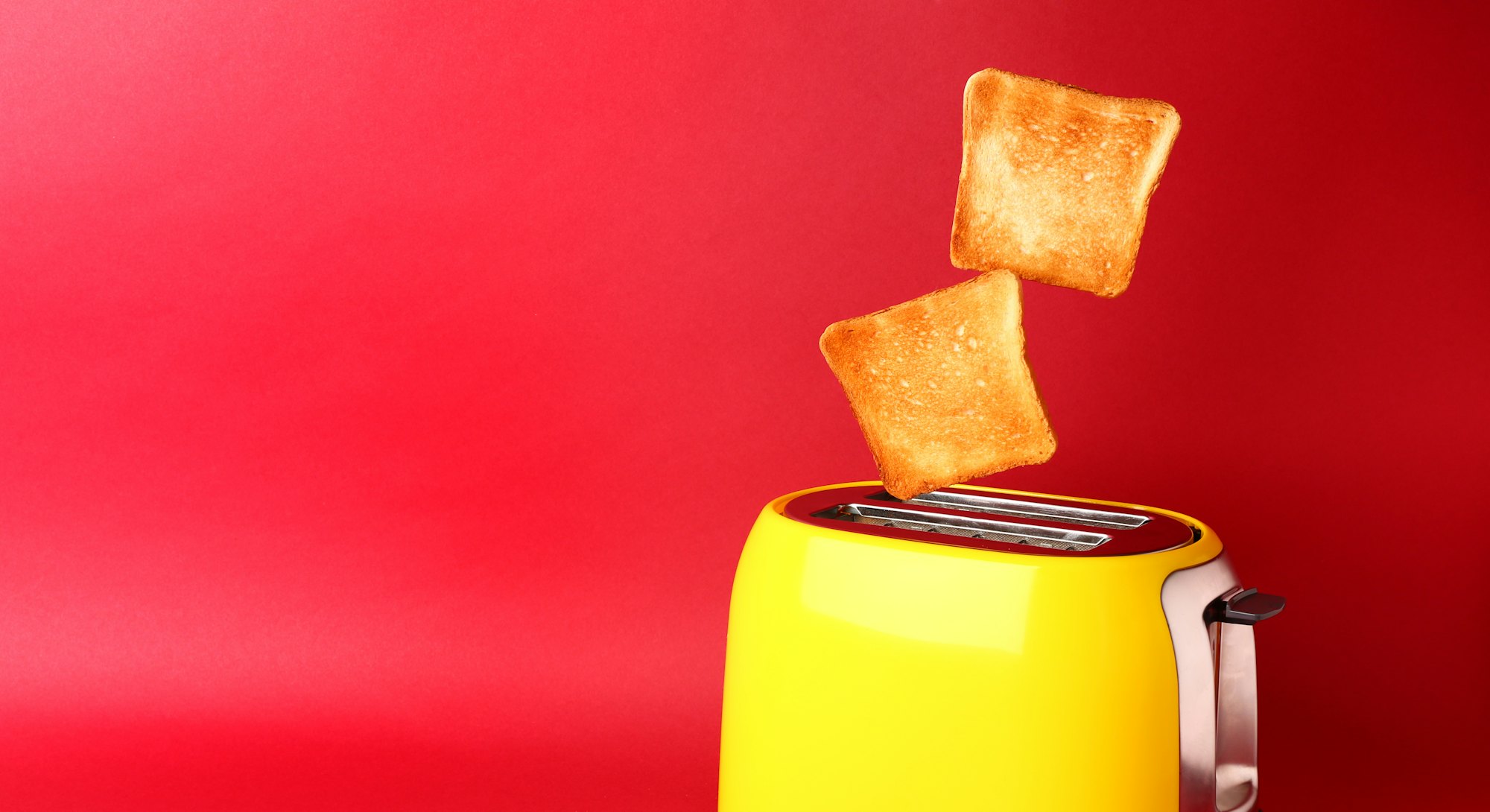 Toaster with bread slices on color background