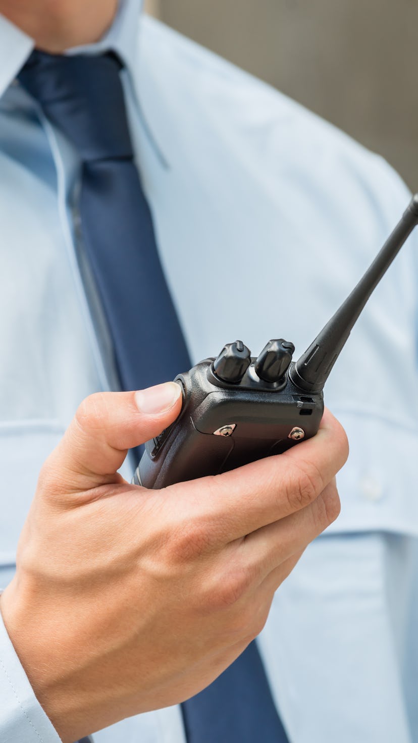 Close-up Photo Of Security Guard Holding Walkie-talkie