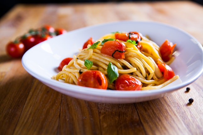 Fresh pasta with garlic Cherry Tomatoes and basil. Deliciosu Pasta Plate. Raw vegan pasta. Spaghetti. Italian food. Italy. Roma. Fine dining. Healthy food. Fresca Pasta. Vegetarian