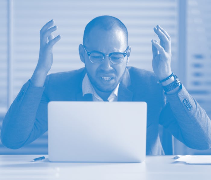 Angry stressed african business man using laptop mad about broken computer online problem annoyed wi...