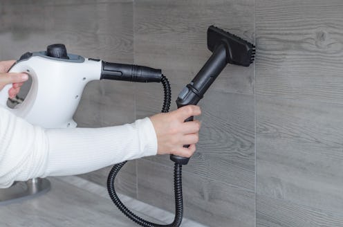 Home cleaning. Hand cleaning wall tile on the kitchen