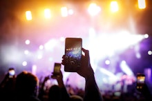 Hand with a smartphone records live music festival, live concert, live concert.