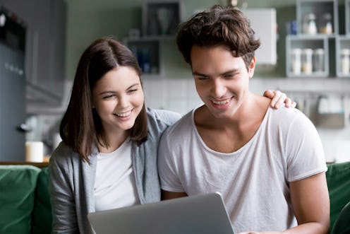 Happy millennial couple smiling looking at laptop screen making video call, young man and woman cust...