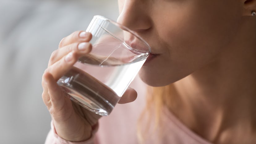 Close up cropped image thirsty woman holding glass drinks still water preventing dehydration, helps ...