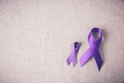 A large ada small purple ribbon on a grey surface and they are commonly used to raise awareness abou...