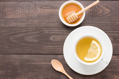 Tea with lemon and honey on the wooden background.