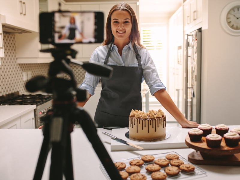 Woman recording video in her home kitchen. Pastry chef creating content for video blog.