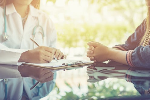 Asian female Doctor and patient are discussing something ,Having Consultation,Medical physician work...