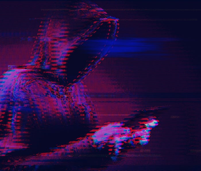 Cybercrime concept with hooded hacker using tablet computer, modern futuristic digital glitch effect