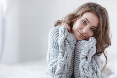 woman indoor portrait. Young beautiful woman in warm knitted clothes at home. fashion. Autumn, winte...