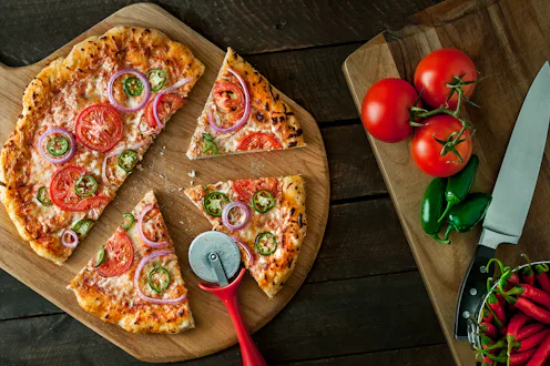 Homemade pizza on peel with ingredients