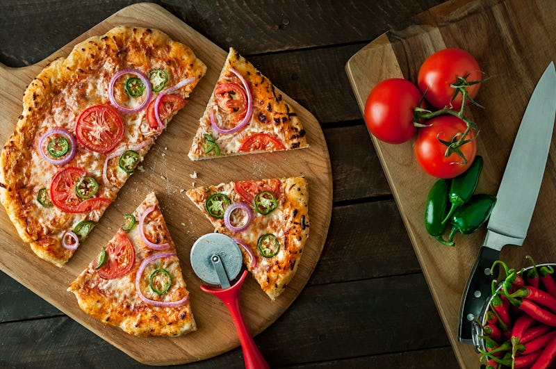 Homemade pizza on peel with ingredients