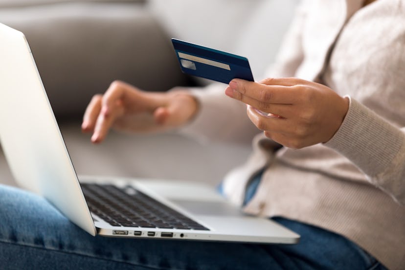 Close up woman shopping, paying by credit card, buying goods or ordering online, using laptop, login...