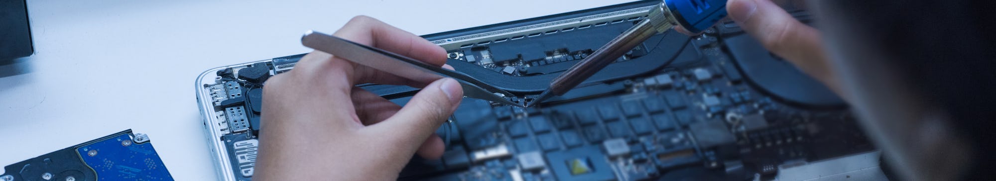 The engineer repairs the laptop and the motherboard.