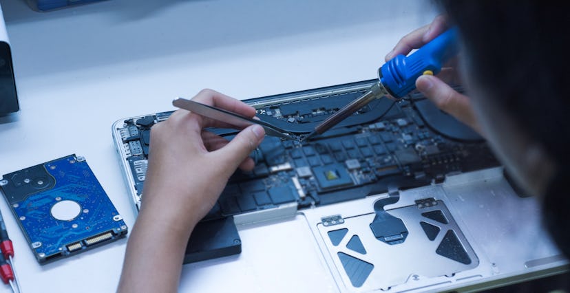 The engineer repairs the laptop and the motherboard.