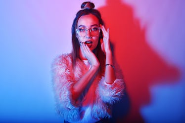 Fashion portrait of young elegant girl in glasses. Colored background, studio shot. Beautiful brunet...