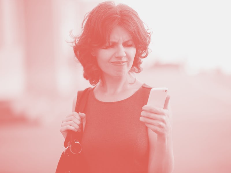 Portrait of annoyed stressed office young woman holding cellphone in hands on the city street in sum...
