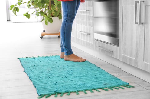 Woman standing on rug in kitchen