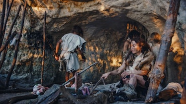 Tribe of Hunter-Gatherers Wearing Animal Skin Live in a Cave. Leader Brings Animal Prey from Hunting...