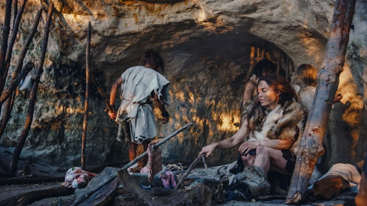 Tribe of Hunter-Gatherers Wearing Animal Skin Live in a Cave. Leader Brings Animal Prey from Hunting...