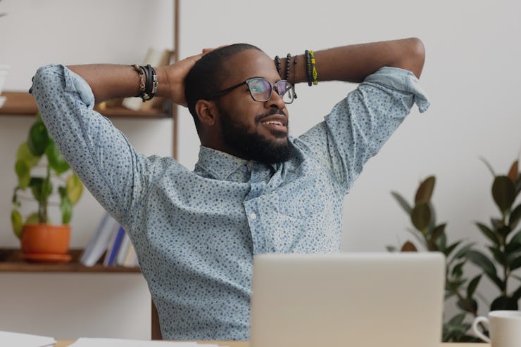 Calm african american business man take break at workplace relaxing finished work, happy black profe...