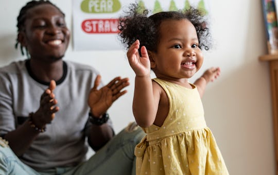 Happy girl and teacher having fun in nursery, baby names like ella