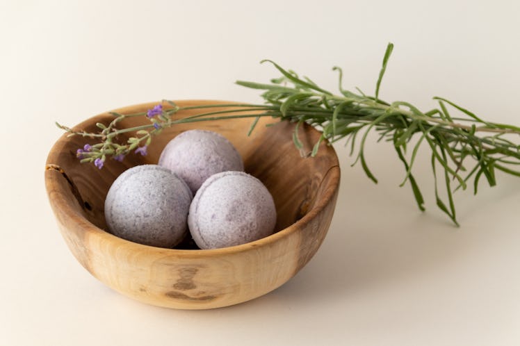 Lavender bath bombs in a wooden bowl with lavender cuttings