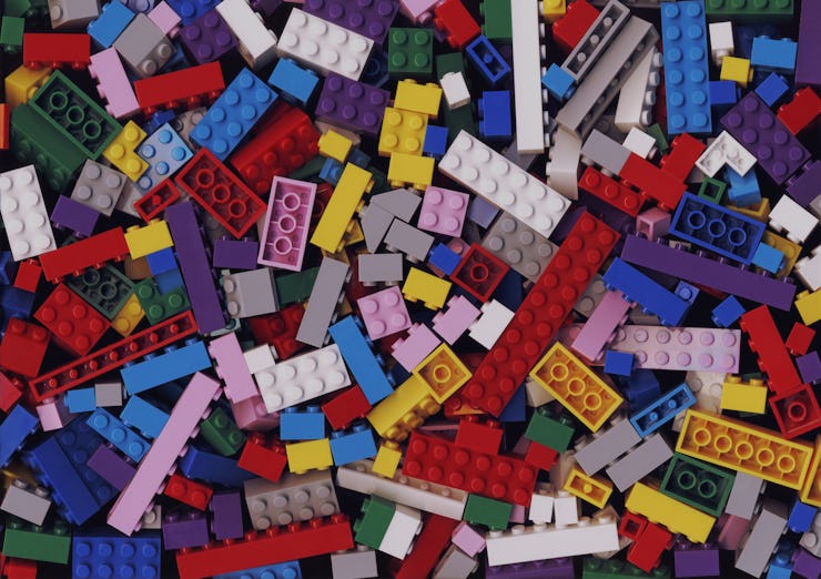 Lot of various colorful Lego blocks background. Many assorted building bricks of bright colors. Educ...