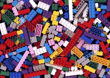 Lot of various colorful Lego blocks background. Many assorted building bricks of bright colors. Educ...