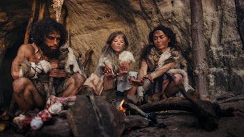 Tribe of Prehistoric Hunter-Gatherers Wearing Animal Skins Live in a Cave at Night. Neanderthal or H...