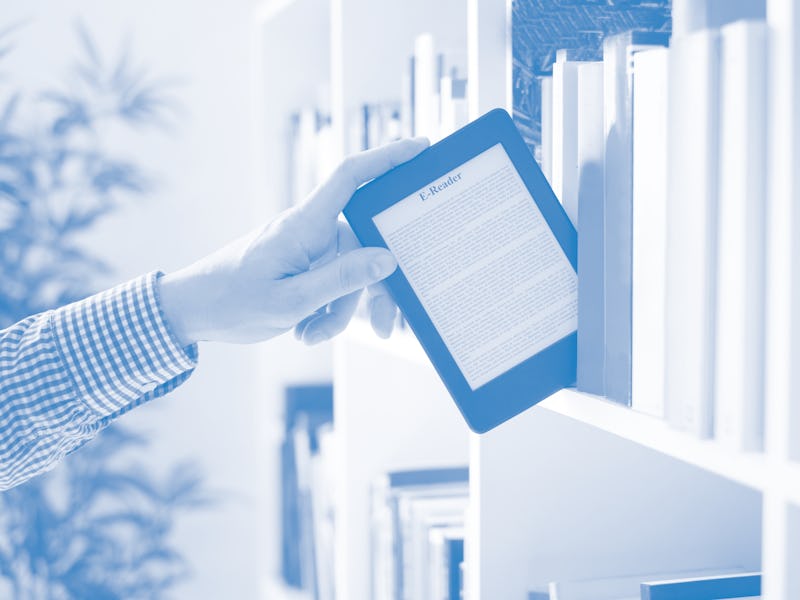 Hands holding ebook on bookshelf background.Copy space on digital tablet display