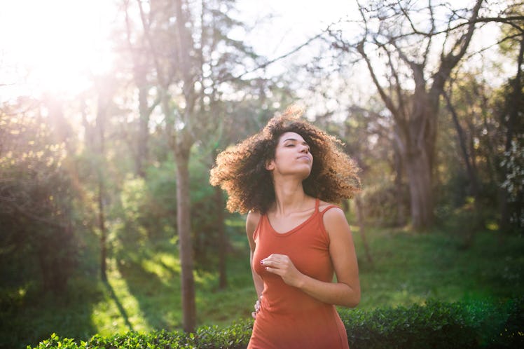 cheerful black afro woman enjoying freedom a sunny summer day in a park