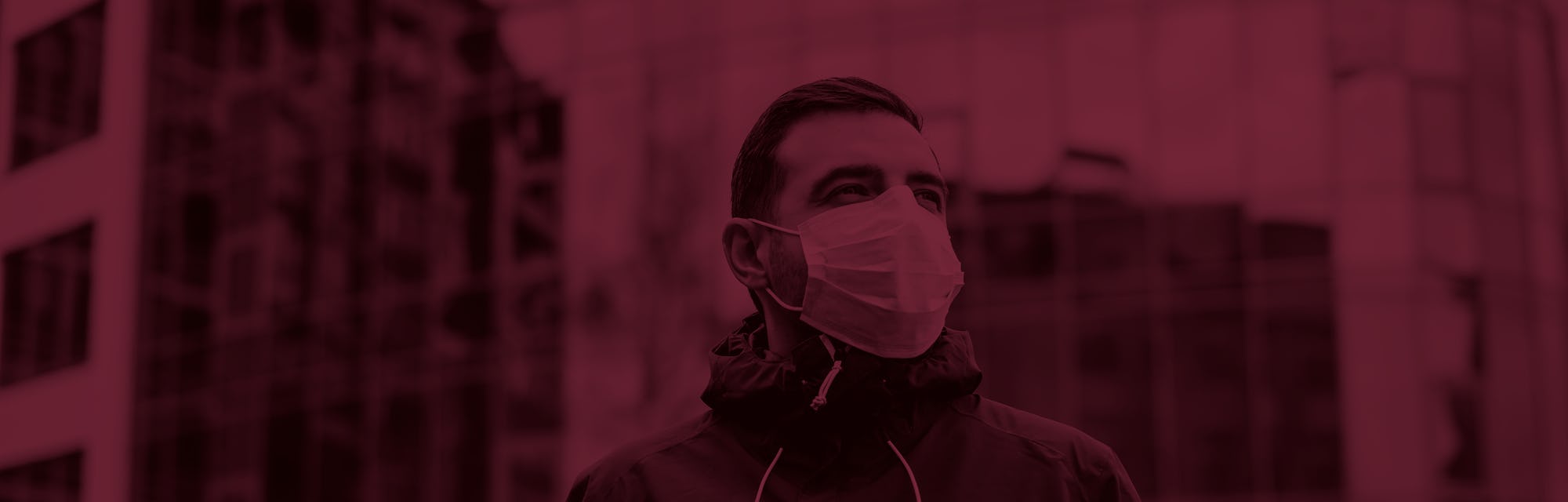 portrait of brunette man in a surgical bandage on a background of a modern building, coronavirus, illness, infection, quarantine, medical mask