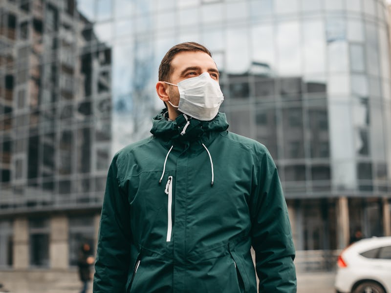 portrait of brunette man in a surgical bandage on a background of a modern building, coronavirus, il...