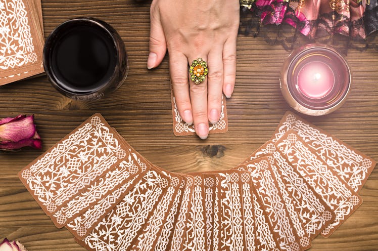 Fortune teller female hands and tarot cards on wooden table. Divination concept. 