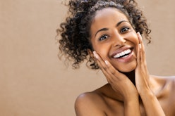 Beautiful young woman smiling after fantastic face treatment. Happy beauty african girl excited afte...