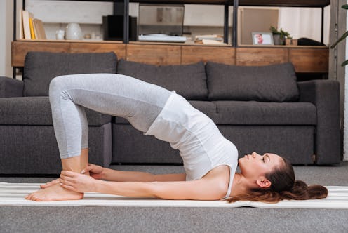 woman practicing bridge pose at home in living room
