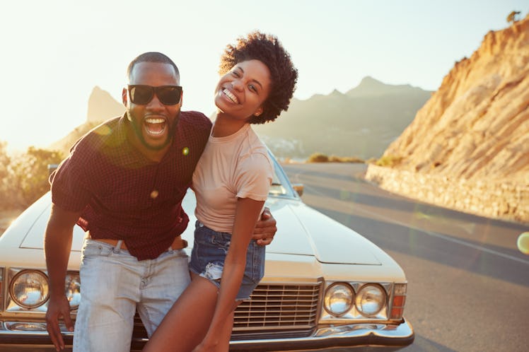 Portrait Of Young Couple Standing Next To Classic Car