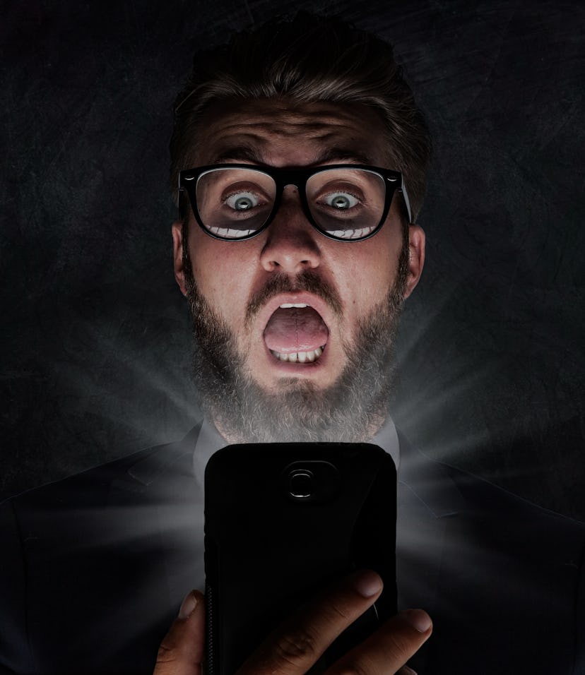 Nerd with glasses is shocked after reading a sms