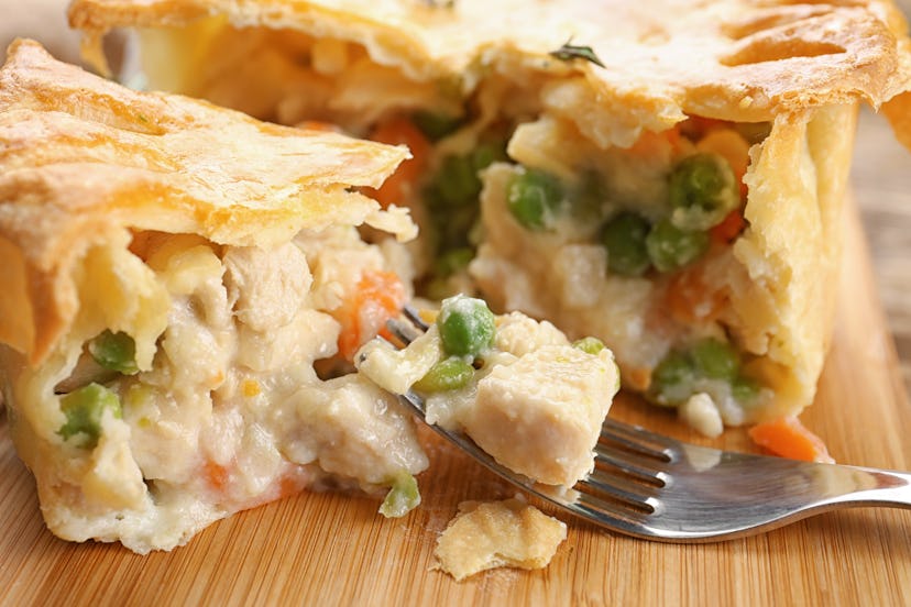 Tasty baked chicken pot pie on wooden board, closeup