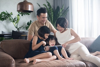 Happy Asian family using the tablet together at home.