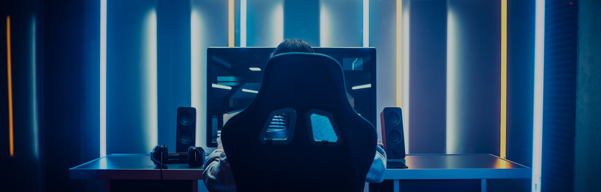 Professional Gamer Playing in First-Person Shooter Online Video Game on His Personal Computer. Room ...