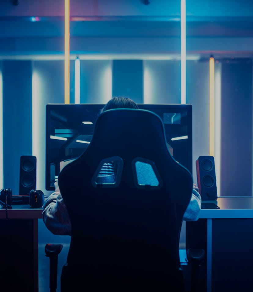 Professional Gamer Playing in First-Person Shooter Online Video Game on His Personal Computer. Room ...