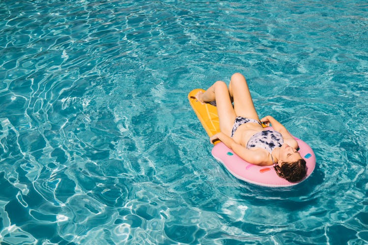Woman lying on water matrass in the pool