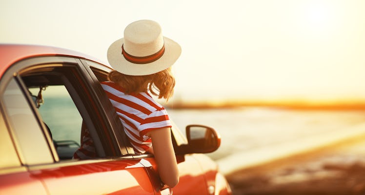 happy woman girl goes to summer travel trip in the  car
