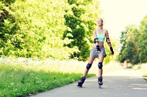 fitness, sport, summer, rollerblading and healthy lifestyle concept - happy young woman in rollerbla...