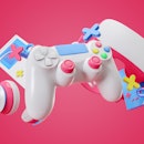 Colorful gamepad, headphones and game console hanging isolated on a pink background. Gaming concept....